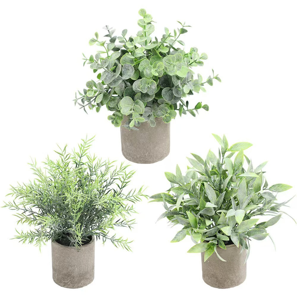 Kunstig grønn plante i dekorativ potte