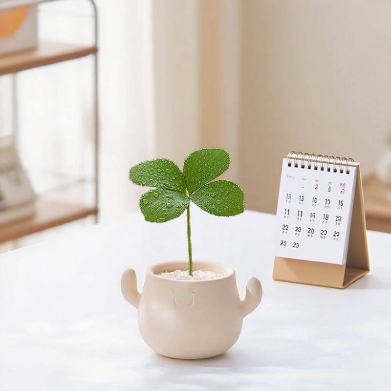 Kunstig grønn plante i dekorativ figurpotte