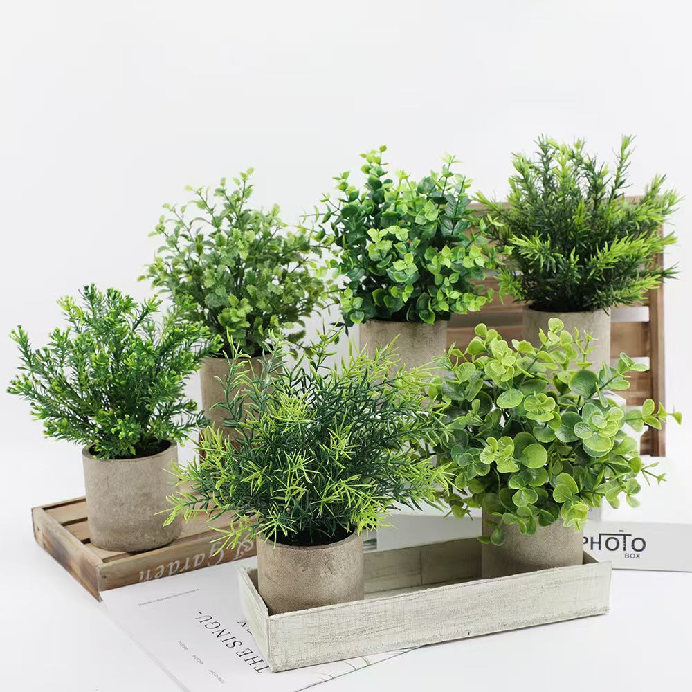 Kunstig grønn plante i dekorativ potte